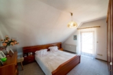 Einfamilienhaus mit ELW in Bestlage von Friesenheim-Heiligenzell - für den Käufer provisionsfrei! - Vergin-Immobilien- Ein Schlafzimmer im Dachgeschoss mit einem Bett und einer Kommode.